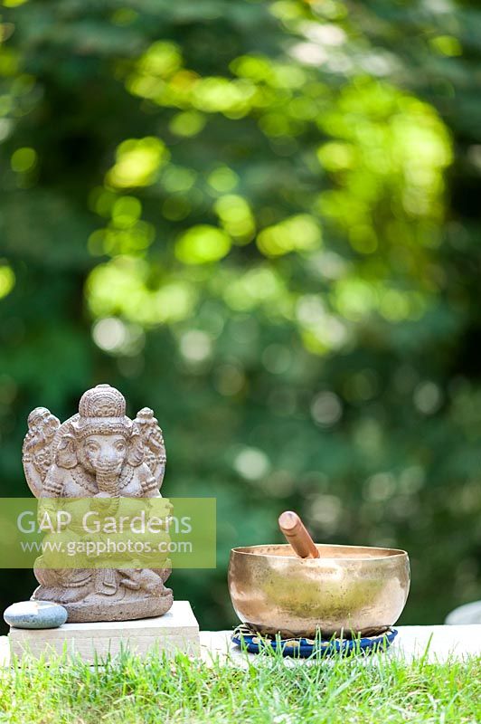 Sculpture de Ganesha à côté d'un bol chantant.