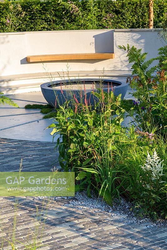 Jardin pluvial en contrebas avec chemin de pierre incurvé et piscine circulaire. 'Jardin vert d'eau du sud-ouest', RHS Hampton Flower Show 2018