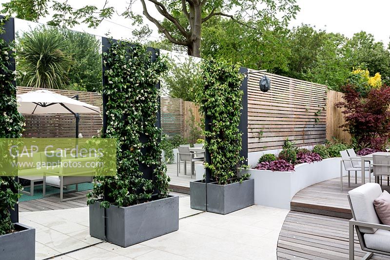 Terrasse en bois courbé et terrasse en pierre avec mobilier de jardin Jardin contemporain à Dulwich