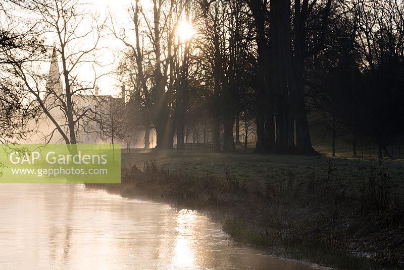 Le soleil du petit matin illumine la brume s'élevant de la rivière Lambourn. Welford Park, Welford, Newbury, Berkshire, Royaume-Uni.