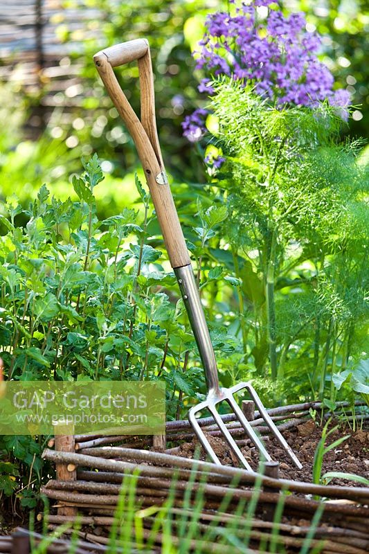 Fourche de jardin en bordure végétale.