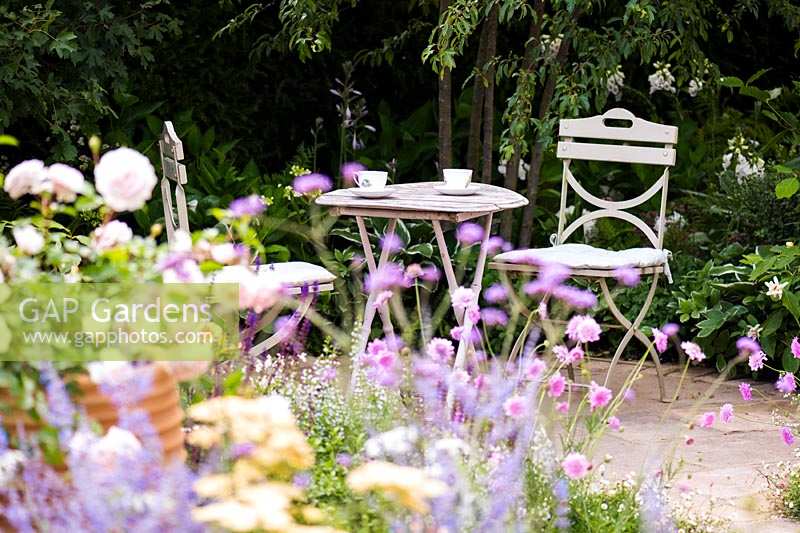 Coin salon dans le jardin du cottage entouré de fleurs d'été pastel douces. Jardin Best of Both Worlds, parrainé par BALI, RHS Hampton Court Palace Flower Show, 2018.