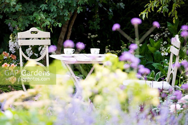 Coin salon dans le jardin du cottage entouré de fleurs d'été pastel douces. Jardin Best of Both Worlds, parrainé par BALI, RHS Hampton Court Palace Flower Show, 2018.