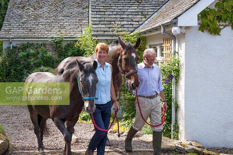 Ian et Clare Alexander conduisant un cheval et un poney devant une maison