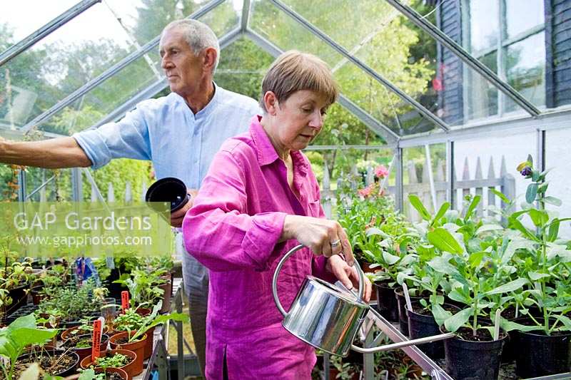 Freda et Barry Waldapfel s'occupent et arrosent les plantes dans leur serre.