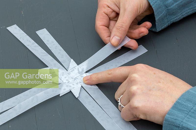 Pliage de bandes de papier décoratif pour faire une décoration d'étoile 3D.