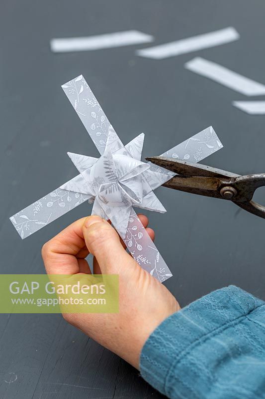 Femme coupe l'excès de papier hors décoration étoile 3D.