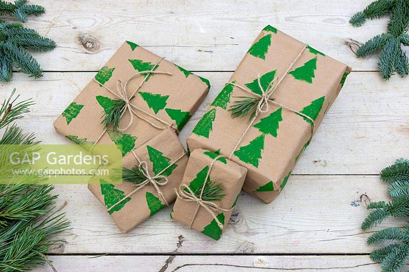 Pile de cadeaux de Noël enveloppés de papier d'emballage imprimé à la main et attachés avec de la ficelle