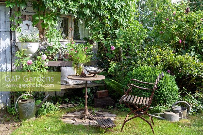 Coin salon en objets de collection vintage dans un jardin de cottage