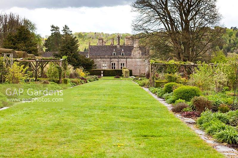 Voir les parterres de fleurs mélangés à la maison. Jardin Miserden, près de Stroud, Gloucestershire, Royaume-Uni.