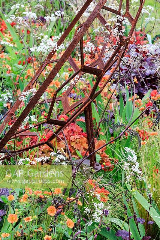 Détail d'une sculpture représentant un télescope entouré de plantations mixtes. The Red Shift Garden, conçu par Julie Bellingham. RHS Malvern Spring Festival, 2019.