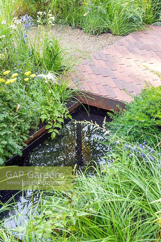 Étang réfléchissant et chemin de briques dans 'South Oxfordshire Landscape Garden '