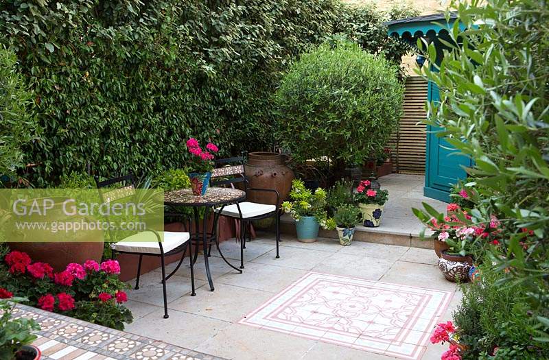 Paire de chaises à petite table ronde dans une cour d'inspiration marocaine.
