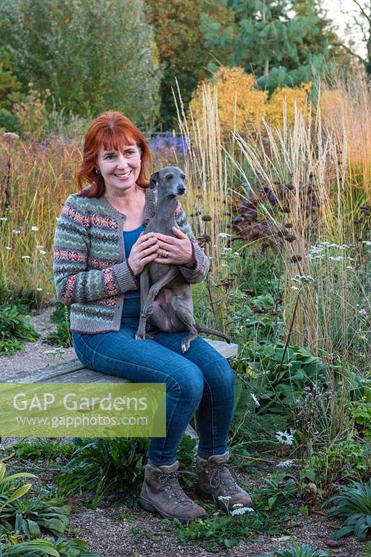 Sarah Murch, jardinière, avec Luka, un lévrier italien, dans son jardin en automne.