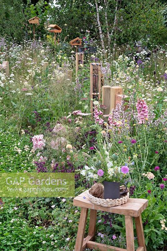Poteaux de clôture respectueux des insectes avec des hôtels d'insectes le long du parterre de fleurs vivaces. RHS Hampton Court Festival 2019.