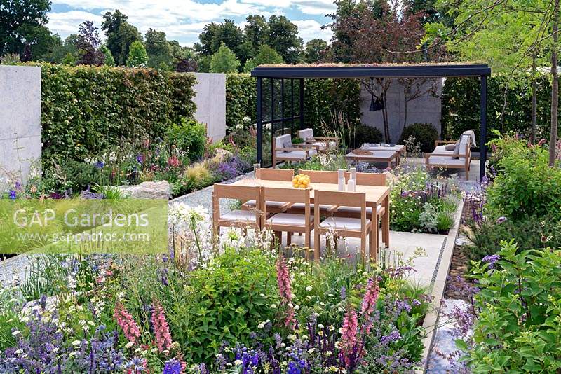 Salle de jardin ouverte en bois et acier avec toit végétal vert. Jardin extérieur contemporain. RHS Hampton Court Festival 2019.