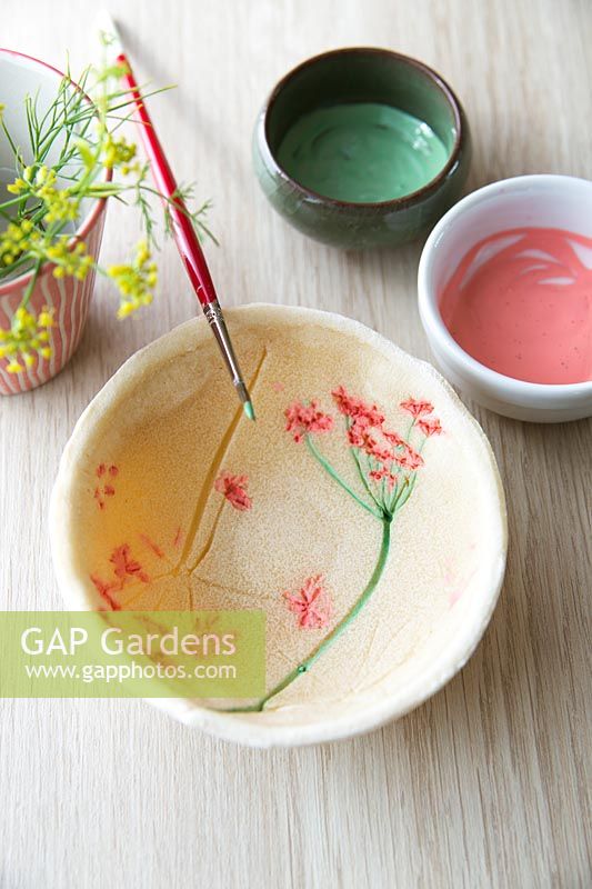 Empreintes de fleurs fraîchement peintes sur un bol de pâte à sel