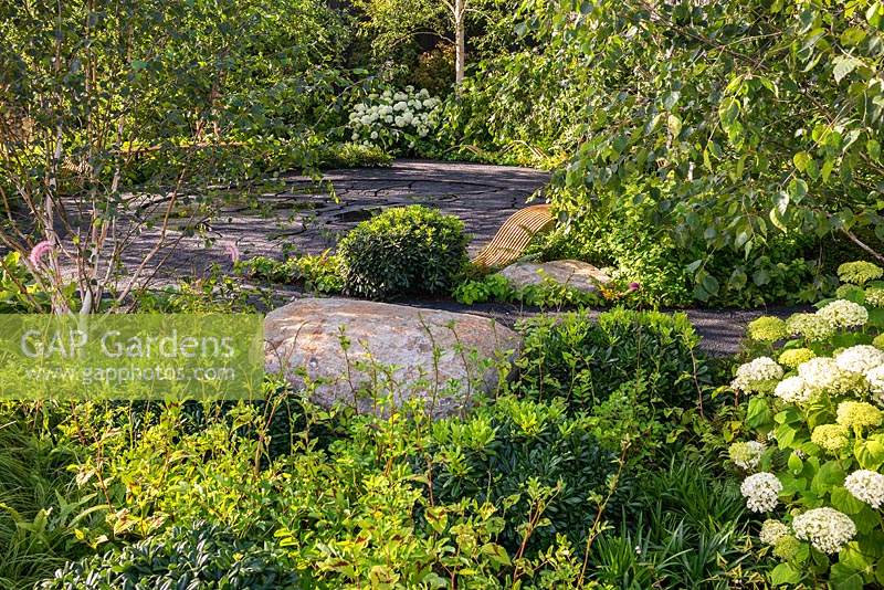 Plantation de feuillage et pierre naturelle dans un jardin verdoyant et ombragé. RHS Hampton Court Palace Garden Festival 2019. Commanditaire: Smart Energy GB