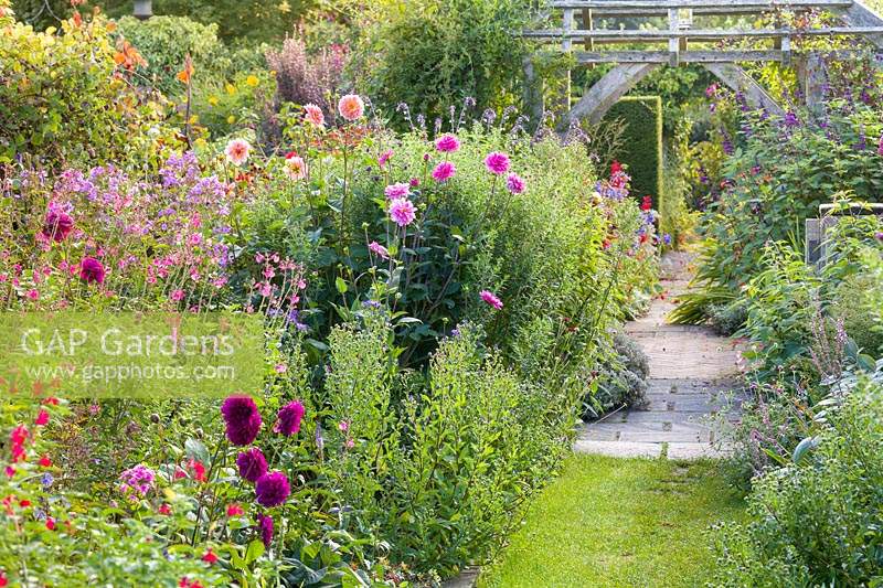 Le jardin Lanhydrock, Wollerton Old Hall Garden, Shropshire, Royaume-Uni. Le jardin cadran solaire avec sa pergola en bois. La plantation comprend: Dahlias, Phlox paniculata, Eupatoriums et Salvias