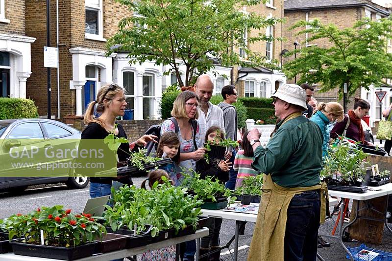 Les gens qui achètent des plantes de décrochage communautaire dans la rue urbaine. Wilberforce Road Gardeners vente d'usine, London Borough of Hackney.