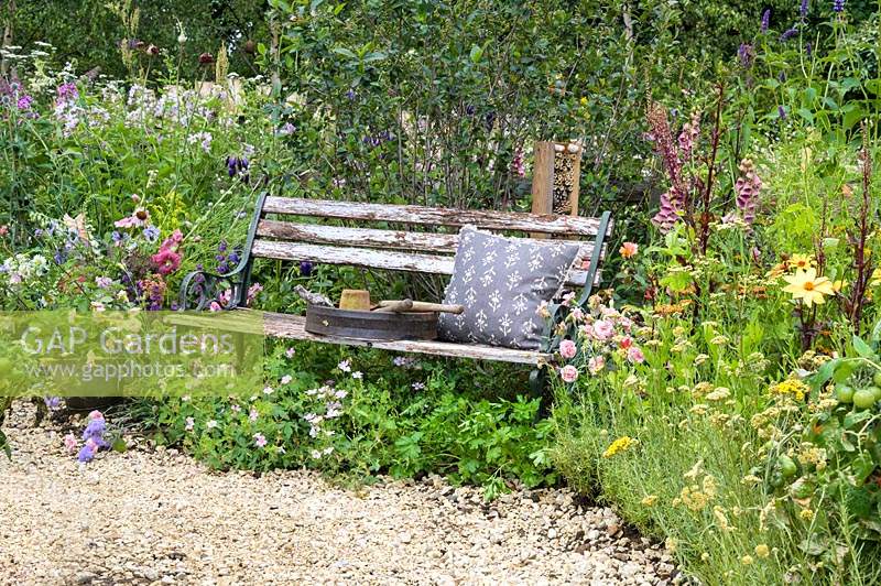 Banc en bois et parterres de fleurs surdimensionnés le long du chemin de gravier - Le BBC Spring Watch Garden - RHS Hampton Court Festival 2019.