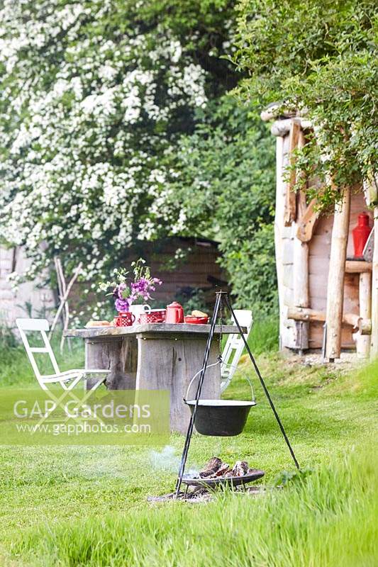 Table et chaises en bois rustique, set de table pour le petit déjeuner - cheminée avec cuisine en arrière-plan.