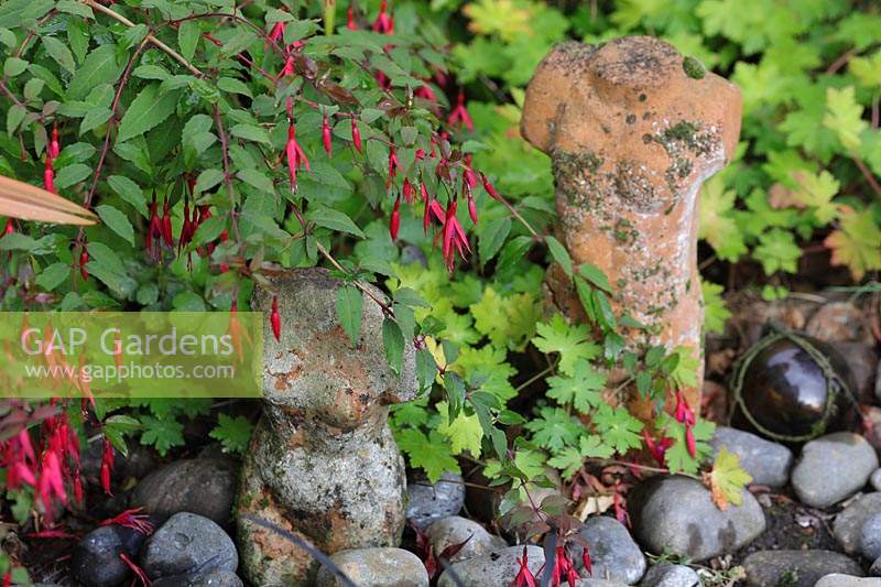 Fuchsia et géranium autour de petites figures issues de galets