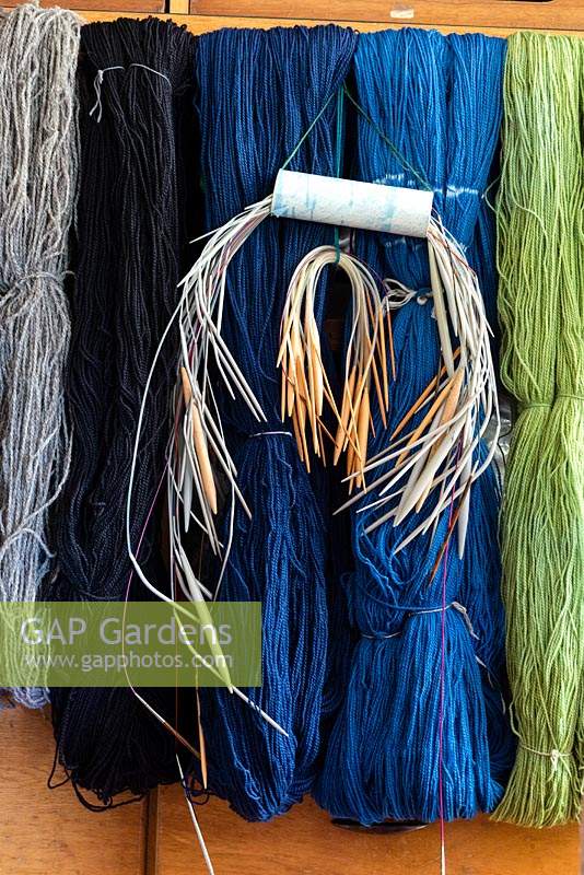 Alison Ellen Hand Knits studio - Aiguilles à tricoter suspendues avec des écheveaux lâches de laine qui ont été teints par immersion à l'aide de colorants acides pour donner une gamme de couleurs naturelles