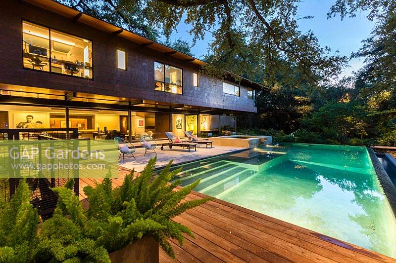 Vue sur terrasse en bois, piscine, terrasse vers maison contemporaine