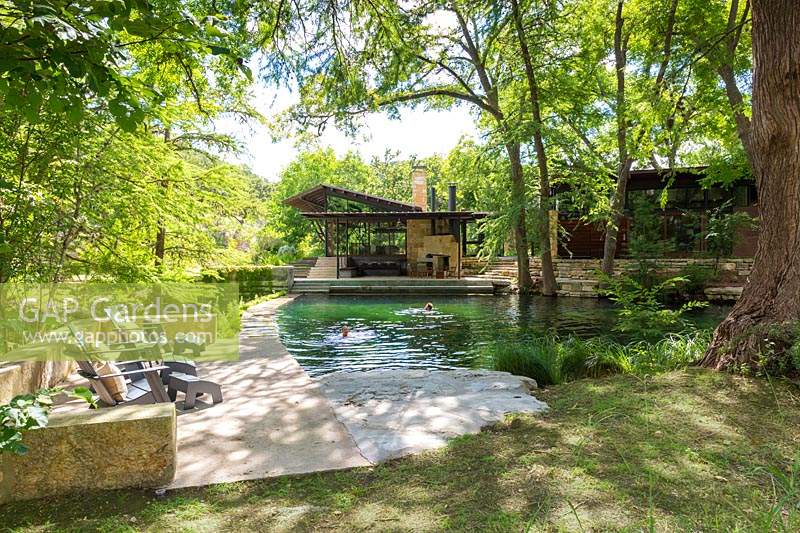 Les gens nager dans l'étang de baignade à Mill Creek Ranch à Vanderpool, Texas conçu par Ten Eyck Landscape Inc, juillet.