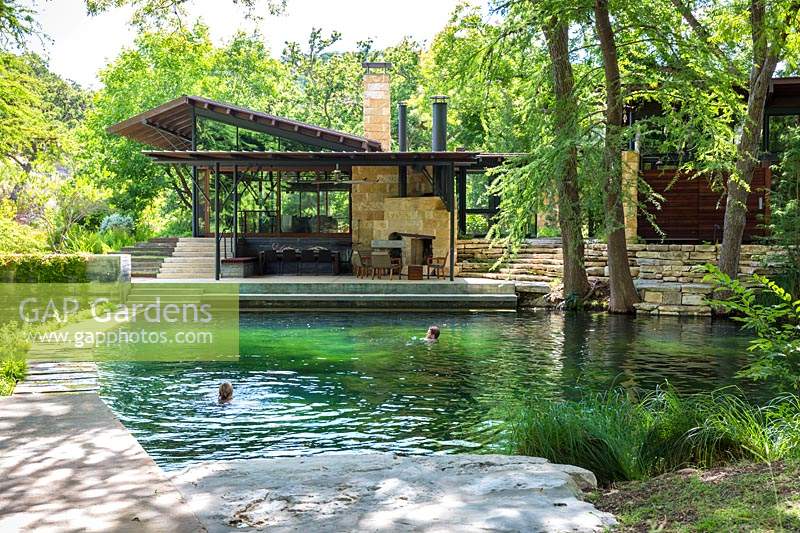 Les gens nager dans l'étang de baignade à Mill Creek Ranch à Vanderpool, Texas conçu par Ten Eyck Landscape Inc, juillet.