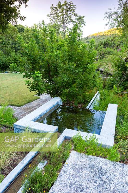 Caractéristique intégrale de l'eau en béton au ranch Mill Creek à Vanderpool, Texas, conçue par Ten Eyck Landscape Inc, juillet.
