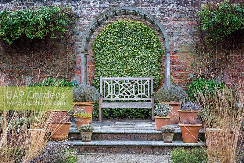 Banc et pots dans le jardin englouti à Littlethorpe Manor, Yorkshire, UK. Conçu par Eddie Harland.