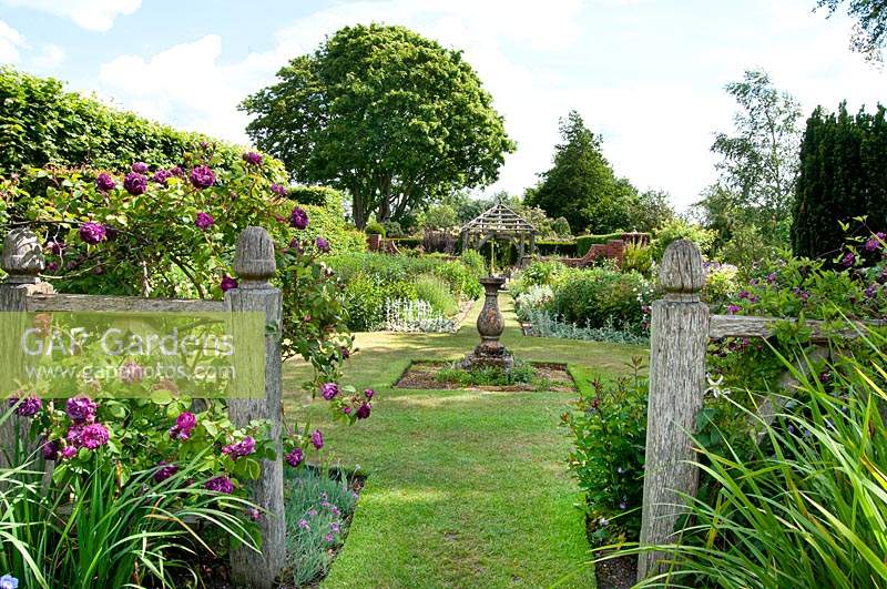 Vue à travers le jardin d'Alice au jardin cadran solaire et au jardin Llanhydrock au-delà à Wollerton Old Hall Garden, Shropshire.