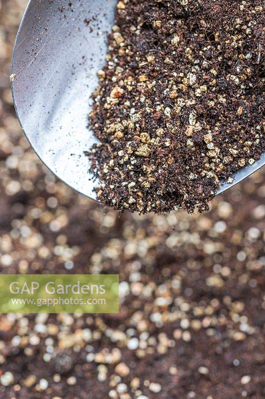 Utiliser une cuillère pour couvrir les graines nouvellement semées avec un mélange de compost et de vermiculite