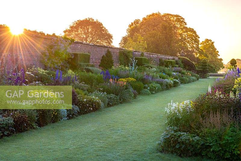 Les lits de fleurs herbacés jumeaux de 90 mètres de long à Arley Hall. Vu au lever du soleil.