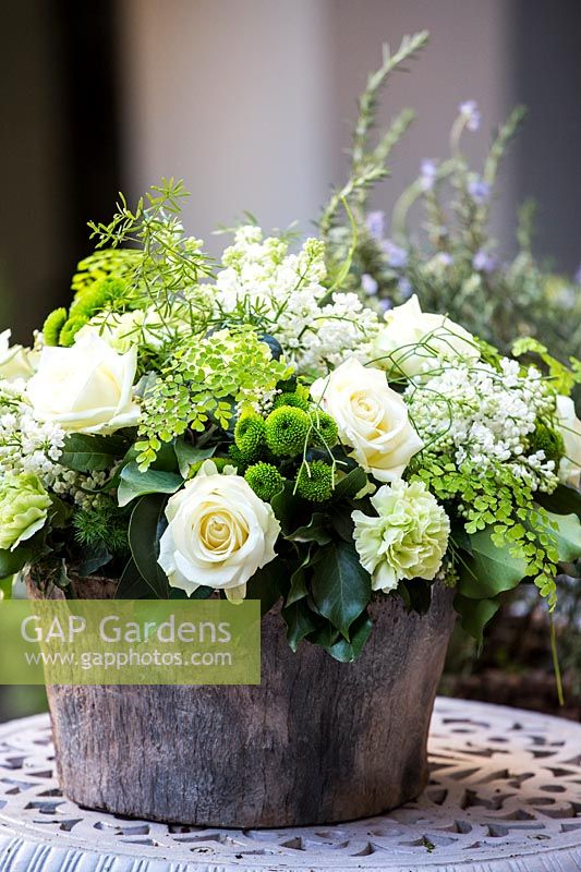 Pot en bois moderne avec arrangement floral blanc et vert.