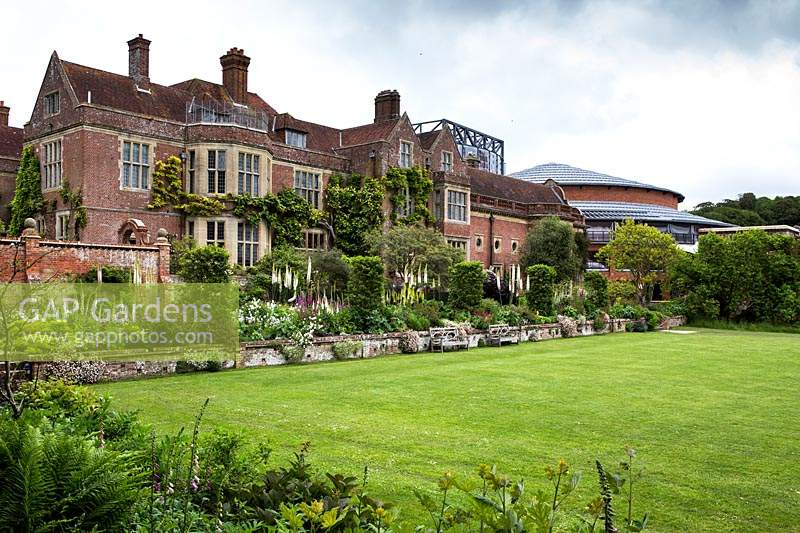 Parterres de printemps mixtes bordant la pelouse devant la maison de Glyndebourne