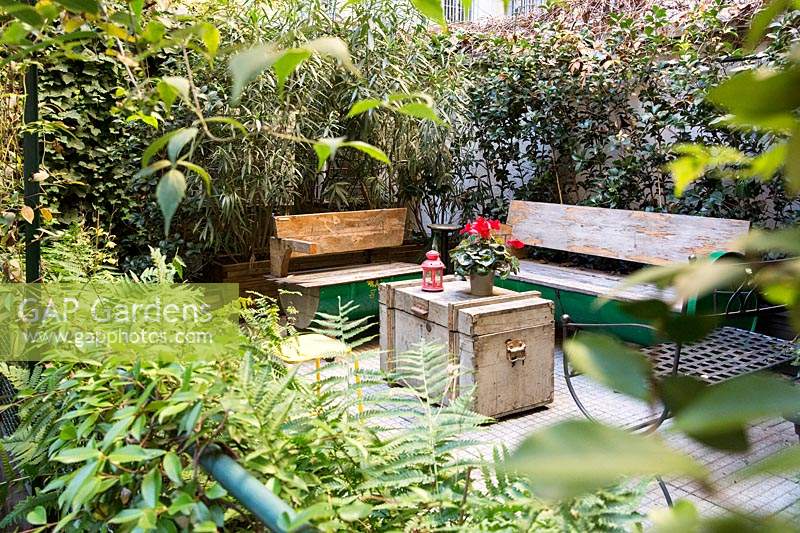 Bancs en bois et table de coffre dans le jardin de la cour.