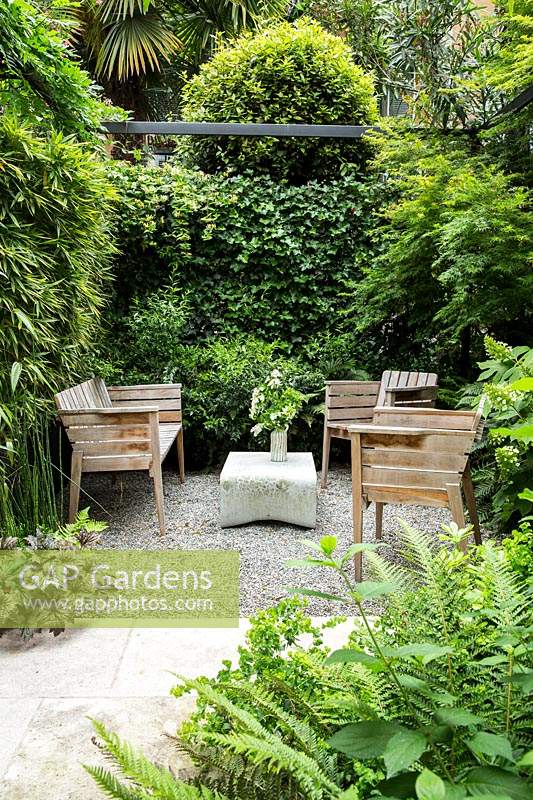 Un coin privé du jardin avec des sièges projetés par Phyllostachys bissetii - Bambou, Hedera hibernica - Lierre et Hydrangea quercifolia 'Pee Wee'