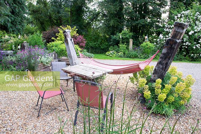 Un hamac dans un jardin de gravier avec table et chaises