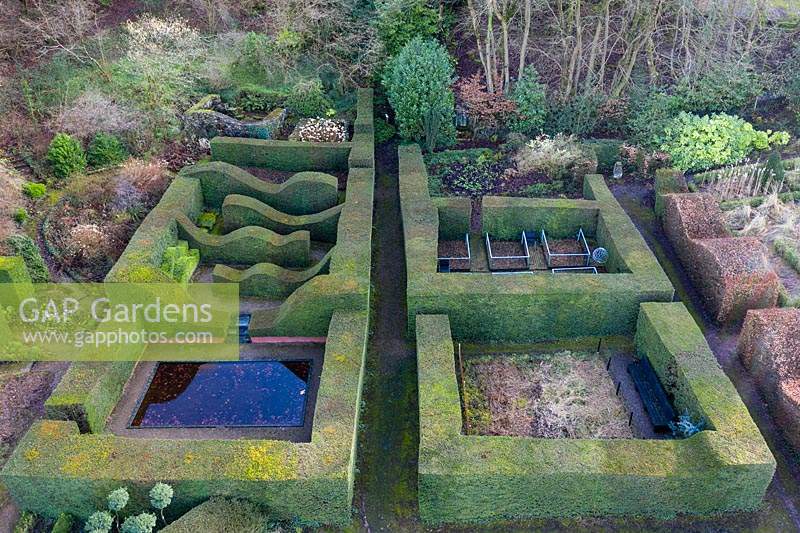 Vue sur Reflecting Pool et Hedge Gardens. Haies et colonnes formelles de Taxus baccata. Veddw House Garden, Monmouthshire, Pays de Galles, Royaume-Uni. Jardin conçu et créé par Anne Wareham et Charles Hawes.