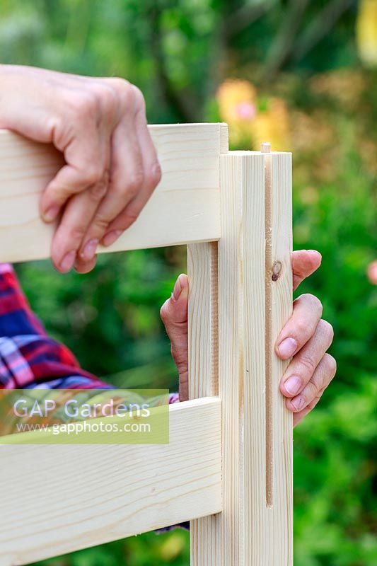 Close up detail insertion de panneaux latéraux en bois dans un bosquet prédécoupé