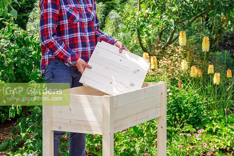 Insérer une base en bois dans une jardinière construite à partir d'un kit