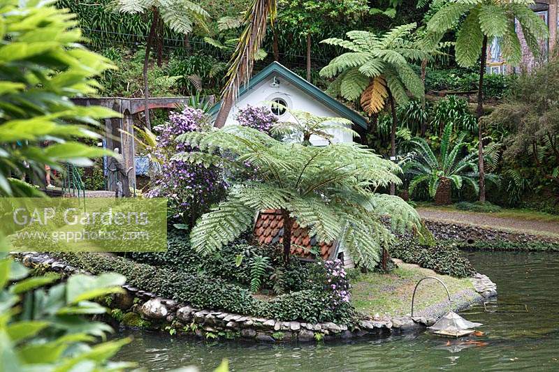 Maison de canard décorative près de l'eau dans un jardin tropical