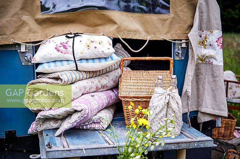 Lot de coussins et couvertures florales vintage à l'arrière du landrover