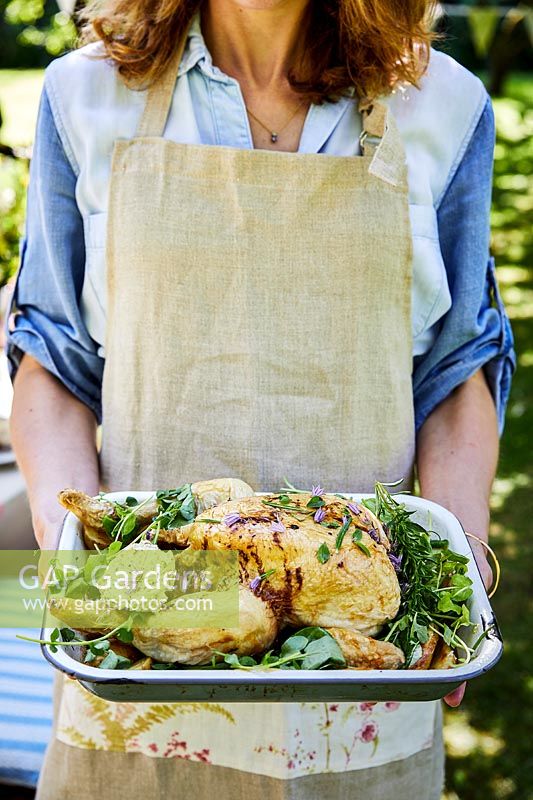 Woman holding poulet rôti aux herbes