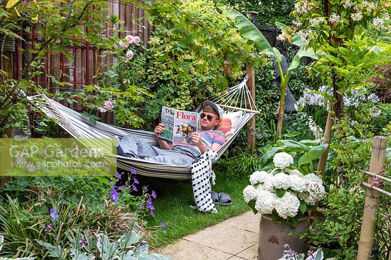 Propriétaire de jardin Ross se détendre dans un hamac en lisant