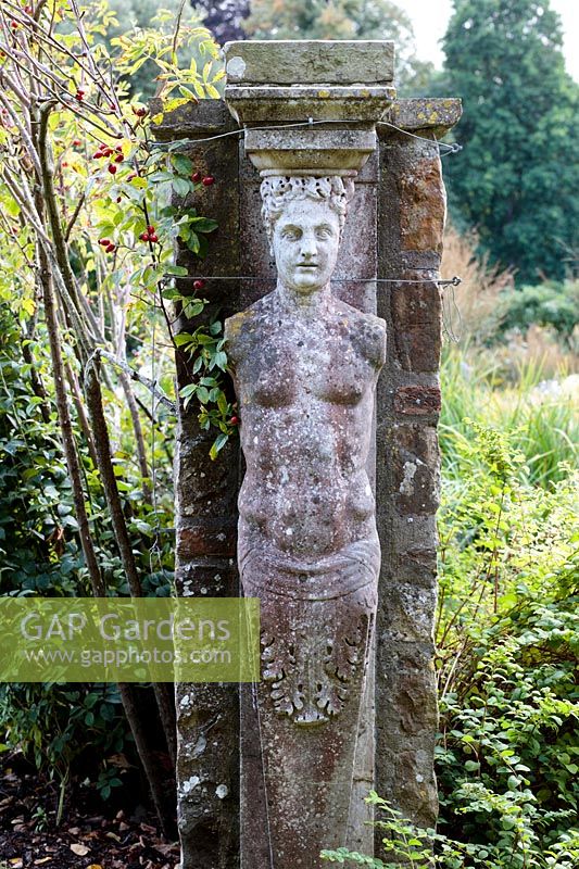 Sculpture de jardin figure intégrée dans un pilier de jardin
