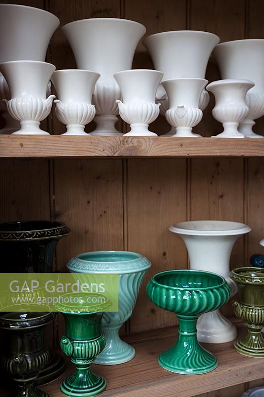 collection de vases et d'urnes blancs et verts dans l'atelier de composition florale.